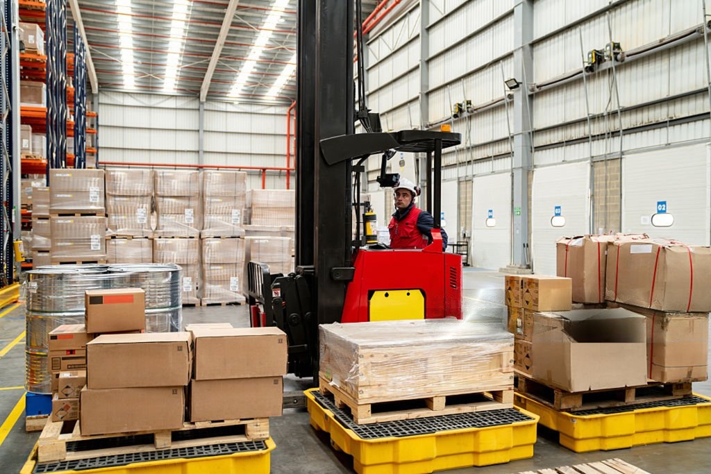 Warehouse worker moving palletized cargo